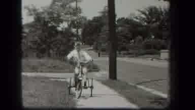 New York USA (1939): Old Film Clip Of A Young Boy On A Tricycle Pedaling Backwards