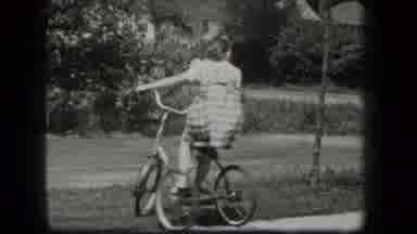 New York USA (1939): A Young Girl In A Checkered Dress Turning And Riding A