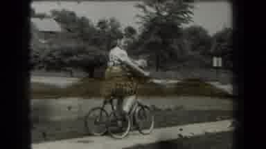 New York USA (1939): Young Girl Rides Bike And Young Boy Looks Into The Camera
