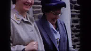 New York USA (1958): Two Middle Aged Ladies Arm In Arm Walking Out Of A Building