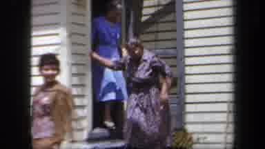 New York USA (1958): Many Women Coming Out Of The House To Greet Visitors