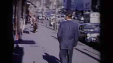 New York USA (1959): Man In Blue Suit Walks On Sidewalk Looking Into Store Window