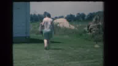 New York USA (1959): People Walking Around The Side Of A House To The Backyard On