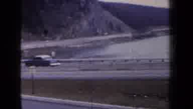 New York USA (1959): Car Driving On Highway Along A Coastline With A Mountain