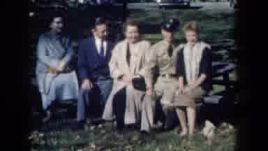 New York USA (1959): 1950s Men And Women Watching Dog Play In A Park From A Park