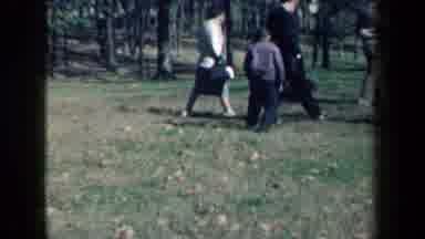 New York USA (1959): Black Dog Running Through A Group Of People Who Are Walking