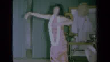 California USA (1961): Girl Hula Dancing With Musical Instrument White Lei
