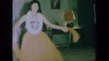 California USA (1961): Girl Hula Dancing In A Grass Skirt Wearing A Lei With Pom