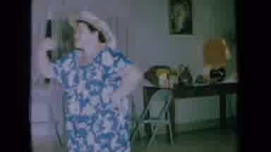 California USA (1961): An Old Lady With A Blue Flowered Dress On And A Tan Hat