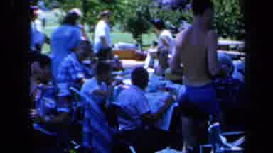 California USA (1961): Group Of People Sitting Around Picnic Table Eating In Park