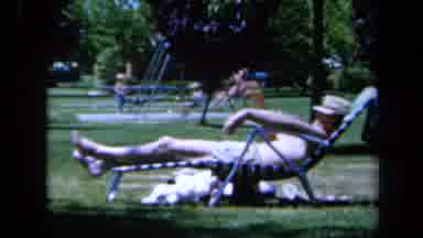 California USA (1961): Man Relaxing On A Deckchair In The Park Nearby A Mother And