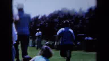 California USA (1961): A Boy Is Running Alongside Another Child Outside Surrounded