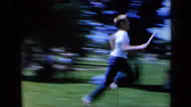 California USA (1961): Boy Running With Baton Then Greeting Another Boy And Man