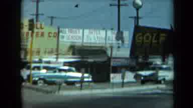 California USA (1969): Cars Moving Around The Community With Signs Horses And