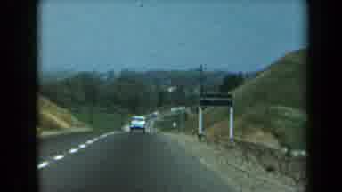 California USA (1969): Car Driving In A Rural Area Maybe By A Farm