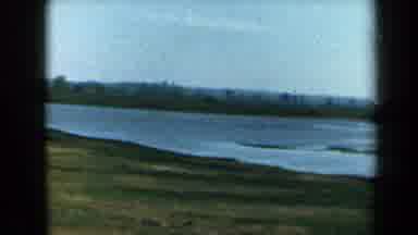California USA (1969): Driving Down A Two Lane Road To View A Lake