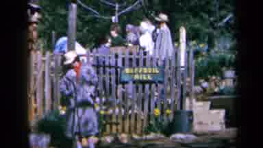 California USA (1969): People Gather Outdoors As Two Young Men Crouch Over A Table