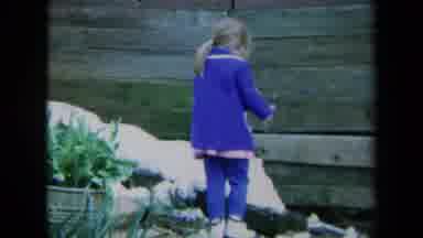 California USA (1969): Little Girl Having Fun Playing Outdoors Around Her House