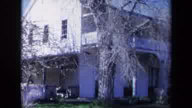 California USA (1969): A Two-Story Wooden House Has Trees Dotting The Lawn And A