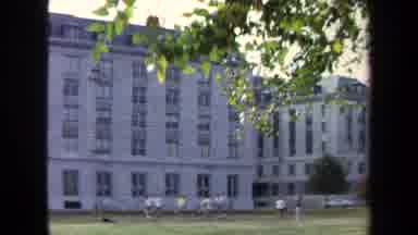 Annapolis USA (1970): Young Men Play A Sport Game In A Park In Front Of A Building