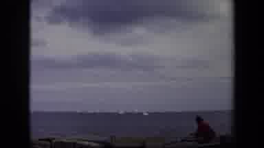 Annapolis USA (1970): People Looking Out At Distant White Sailboats In The Ocean