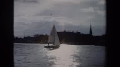 Annapolis USA (1970): Sailboat Moves Slowly Across Water With Sun Shining Down And