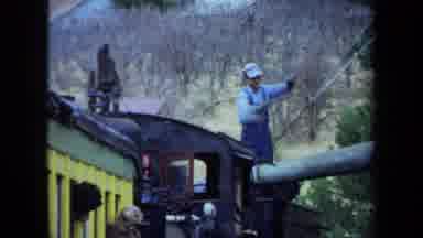 California USA (1970): Train Engineer Lifts A Pipe Dripping With Water