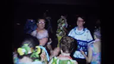 California USA (1971): A Group Of People Wearing Necklaces Of Flowers And Dancing