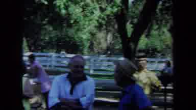 California USA (1971): People Talking At A Park Outdoors With A White Picket Fence