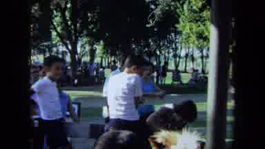California USA (1971): A Group Of People Sitting And Watching A Man In A White
