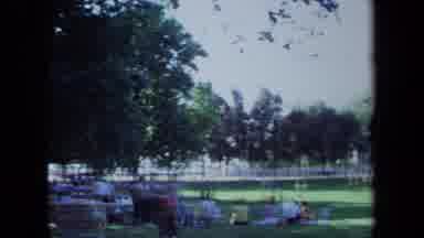 California USA (1971): People Walking Around Outside At Park While Sports Are