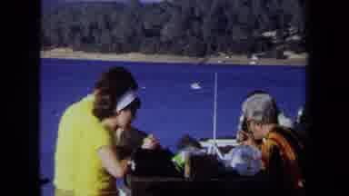 California USA (1971): Family Picnic Lunch At Table At Park Next To Lake In The