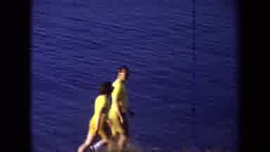California USA (1971): Couple Walking On The Beach While Boys Throw Stones Into