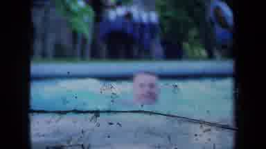 California USA (1971): Two Men Are Standing On The Poolside One Reenacts That He