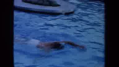 California USA (1971): Man Practices His Swimming Strokes While Females Looks On