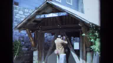 Maine USA (1971): Man Looks Into A Stone Well And Find Yellow Flowers