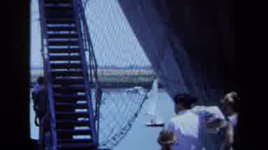 Maine USA (1971): Family Of Three Walks Towards Stairs Near Large Boat Carrying