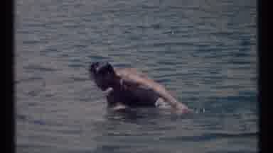 SCAPEGOAT WILDERNESS MONTANA USA .MP-1973: Man Swimming In A Lake While Campers
