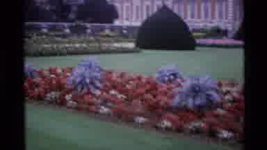 London England (1969): Clock Tower With Round Top In A Garden With Flowers And