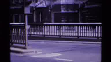 London England (1969): Motorcycle And Cars Driving In Traffic On Bridge Over Water