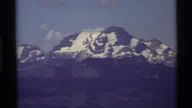 Holland Lake Montana USA (1972): Wide Mountain With Snowy Peaks Zoom Into Scene Of