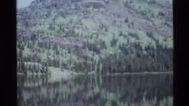 Holland Lake Montana USA (1972): A Luscious Mountain Filled With Greenery Behind A