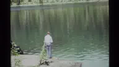Holland Lake Montana USA (1972): Man Fish Water Lake Pole Cast Line Tree Pants