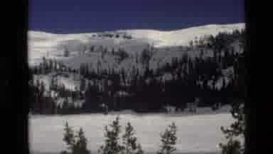 Idaho USA (1972): A Snowy Mountain With Skiers And Ski Racks And The Shadow Of