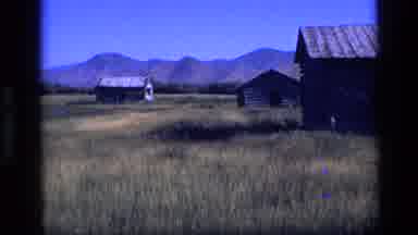 Idaho USA (1972): Stacks Of Hay Under The Mountain View And Houses In The