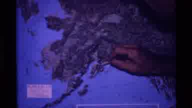 Alaska USA (1977): Someone's Hand Holding A Pen Over A Map And Mountains Covered