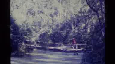 Alaska USA (1977): Hikers With Backpacks Walking In A Park With Bridge Over Creek