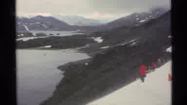 Alaska USA (1977): People Wearing Red Coats Walk On Snow Covered Mountains On A