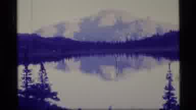 Alaska USA (1977): A Hiking Tail With People Hiking On It And A Lake In Front Of