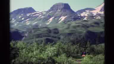 Alaska USA (1977): Pan Of Mountain Range And Forestation With People Hiking